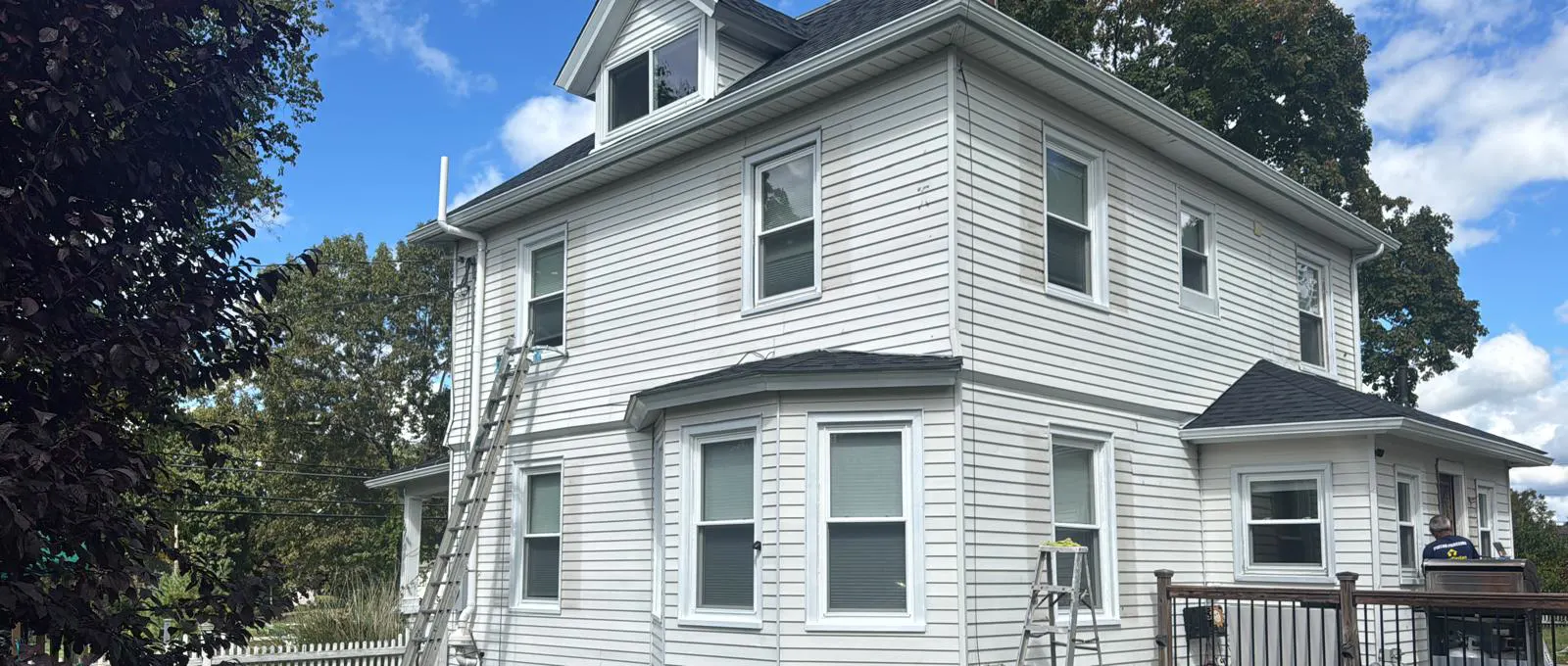 Exterior painting in progress on a white two-story home in Connecticut